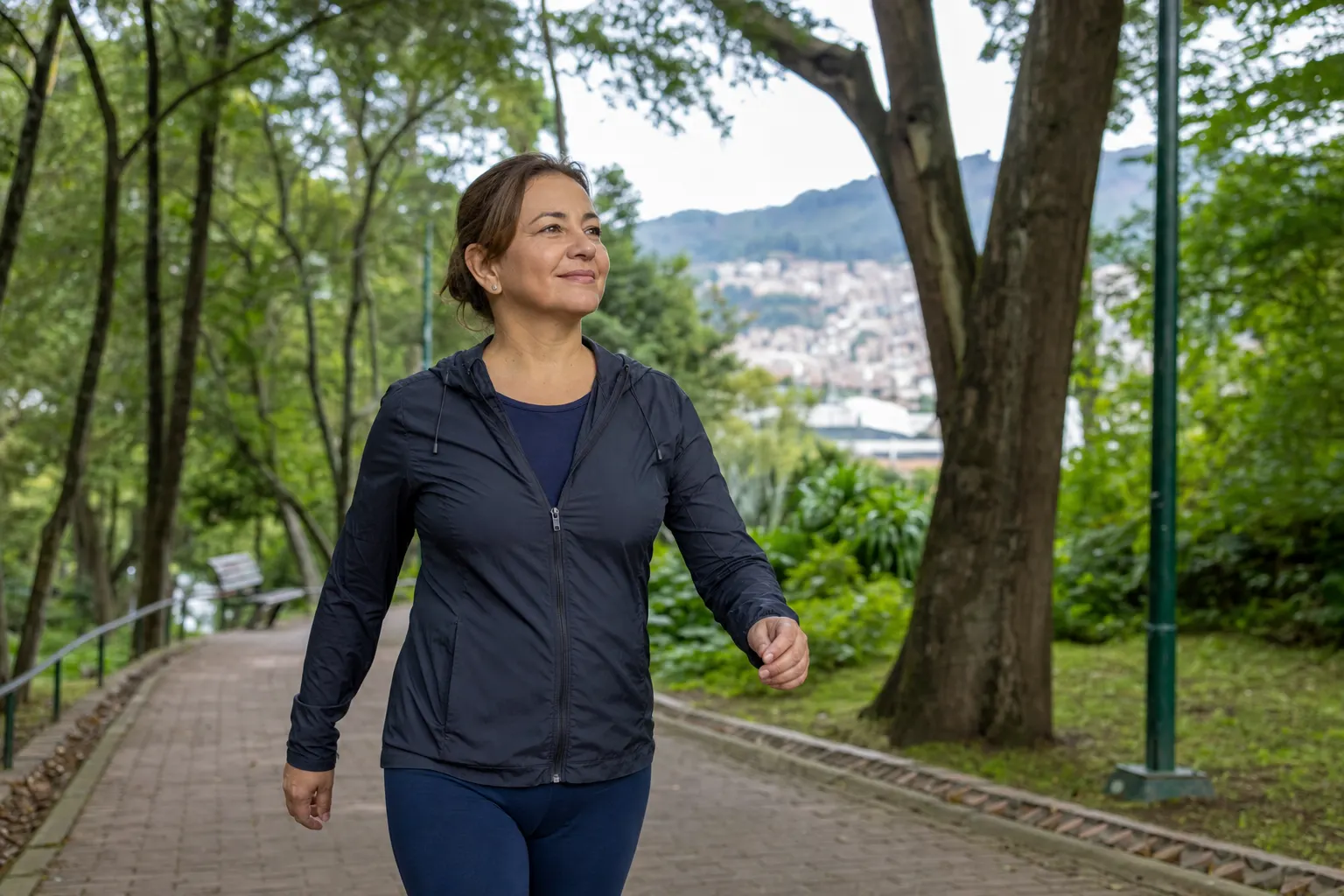 Persona caminando en un parque de Bogotá, rodeada de árboles y disfrutando del aire libre.
