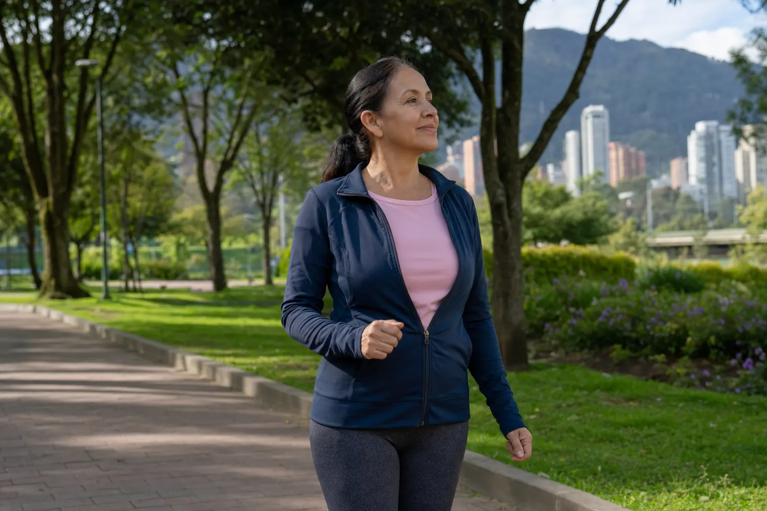 Mujer de mediana edad realizando ejercicios de bajo impacto en un parque en Bogotá.